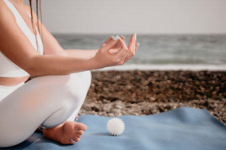 Close up Yoga Hand Gesture of Woman Doing an Outdoor meditation. Blurred sea background. Woman on...