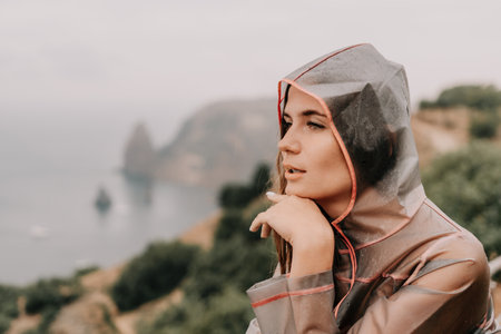 Woman rain umbrella. Happy woman portrait wearing a raincoat with transparent umbrella outdoors on...