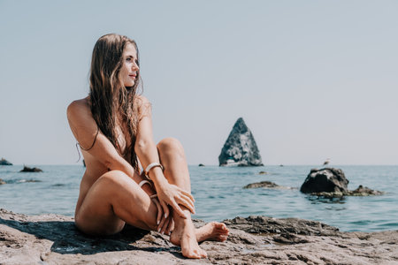 Woman summer sea. Happy woman swimming with inflatable donut on the beach in summer sunny day, surrounded by volcanic mountains. Summer vacation concept.の写真素材
