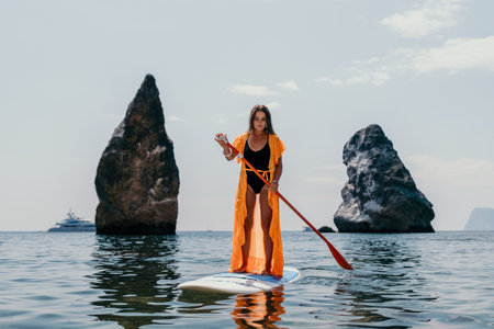 Woman sea sup. Close up portrait of happy young caucasian woman with long hair looking at camera and smiling. Cute woman portrait in bikini posing on sup board in the seaの写真素材