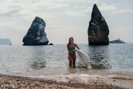 Woman sea sup. Close up portrait of happy young caucasian woman with long hair looking at camera and smiling. Cute woman portrait in bikini posing on sup board in the seaの写真素材