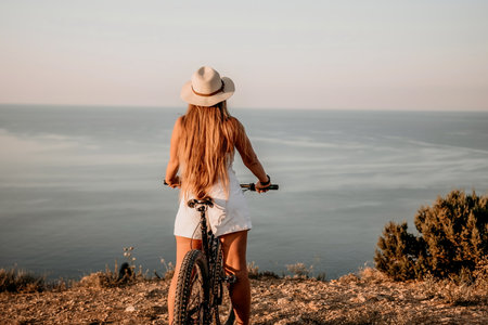Woman travel sea. Happy tourist in hat enjoy taking picture outdoors for memories. Woman traveler posing on the beach at sea surrounded by volcanic mountains, sharing travel adventure journeyの写真素材