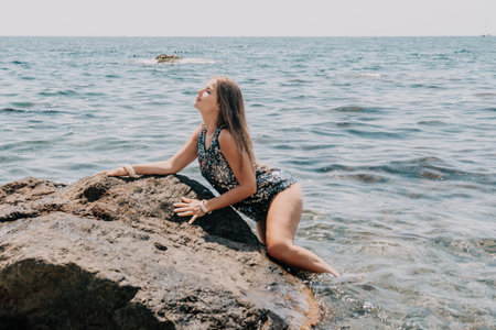 Woman summer travel sea. Happy tourist enjoy taking picture outdoors for memories. Woman traveler posing on the beach at sea surrounded by volcanic mountains, sharing travel adventure journeyの写真素材