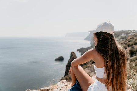 Woman sea yoga. Happy woman meditating in yoga pose on the beach, ocean and rock mountains. Motivation and inspirational fit and exercising. Healthy lifestyle outdoors in nature, fitness concept.の写真素材