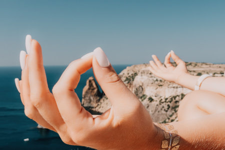Woman sea yoga. Happy woman meditating in yoga pose on the beach, ocean and rock mountains. Motivation and inspirational fit and exercising. Healthy lifestyle outdoors in nature, fitness concept.の写真素材