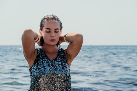 Woman summer travel sea. Happy tourist enjoy taking picture outdoors for memories. Woman traveler posing on the beach at sea surrounded by volcanic mountains, sharing travel adventure journeyの写真素材