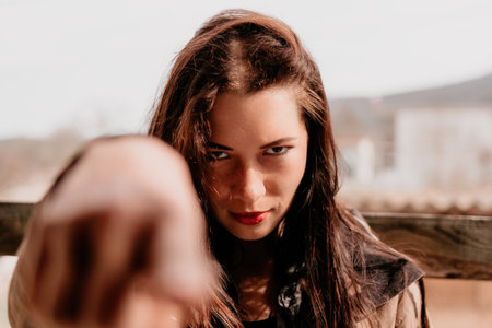 Happy young smiling woman with freckles outdoors portrait. Soft sunny colors. Outdoor close-up portrait of a young brunette woman and looking to the camera, posing against autumn nature backgroundの写真素材