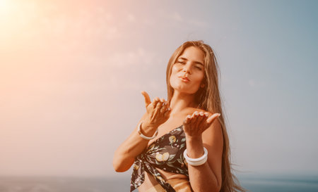 Woman travel sea. Happy tourist taking picture outdoors for memories. Woman traveler looks at the edge of the cliff on the sea bay of mountains, sharing travel adventure journeyの写真素材