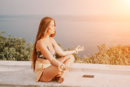 Woman park yoga. Side view of free calm bliss satisfied woman with long hair standing in morning park with yoga position against of sky by the sea. Healthy lifestyle outdoors in park, fitness concept.の写真素材