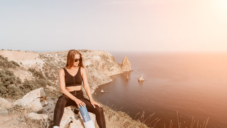 Fitness woman sea. Outdoor workout with fitness rubber bands in park over beach. Female fitness pilates yoga routine concept. Healthy lifestyle. Happy fit woman exercising with rubber band in park.の写真素材
