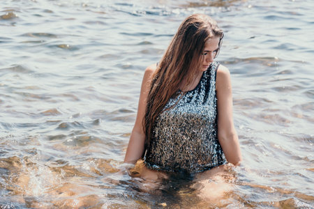 Woman summer travel sea. Happy tourist enjoy taking picture outdoors for memories. Woman traveler posing on the beach at sea surrounded by volcanic mountains, sharing travel adventure journeyの写真素材
