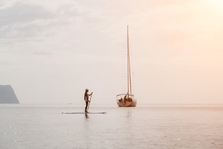 Woman sea sup. Close up portrait of happy young caucasian woman with long hair looking at camera and smiling. Cute woman portrait in bikini posing on sup board in the seaの写真素材