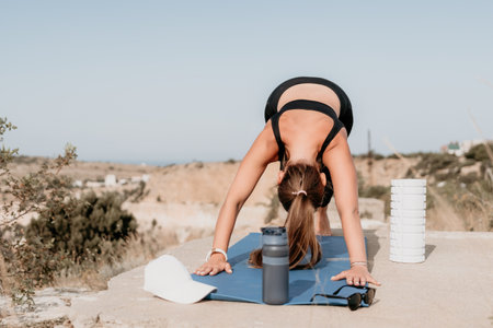 Fitness woman sea. Outdoor workout on yoga mat roller in park near to ocean beach. Female fitness pilates yoga routine concept. Healthy lifestyle. Happy fit woman exercising with rubber band in park.の写真素材