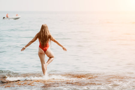 Woman sea yoga. Happy woman meditating in yoga pose on the beach, ocean and rock mountains. Motivation and inspirational fit and exercising. Healthy lifestyle outdoors in nature, fitness concept.の写真素材