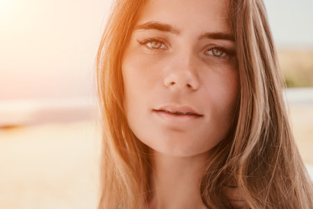 Happy woman portrait in cafe. Boho chic fashion style. Outdoor photo of young happy woman with long hair, sunny weather outdoors sitting in modern cafe.の写真素材