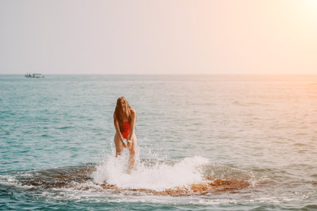 Woman sea yoga. Happy woman meditating in yoga pose on the beach, ocean and rock mountains. Motivation and inspirational fit and exercising. Healthy lifestyle outdoors in nature, fitness concept.の写真素材