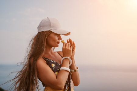 Woman travel sea. Happy tourist taking picture outdoors for memories. Woman traveler looks at the edge of the cliff on the sea bay of mountains, sharing travel adventure journeyの写真素材