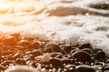 Blurred golden sea at sunset. The sun reflects and sparkles on the waves with bokeh, illuminating the golden sea. Holiday recreation concept. Abstract nautical summer ocean sunset nature background.の写真素材