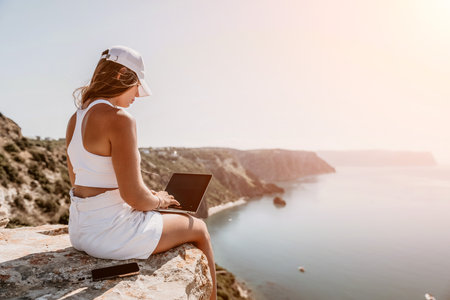 Digital nomad, Business woman working on laptop by the sea. Pretty lady typing on computer by the...