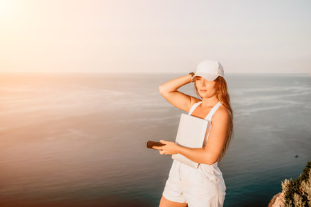 Woman laptop sea. Working remotely on seashore. Happy successful woman female freelancer in straw...