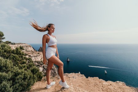 Woman sea pilates. Sporty middle-aged woman training in pilates on yoga mat by sea. concepts of health, wellness, and mindfulness in exercise, promoting the benefits of active and balanced lifestyleの写真素材