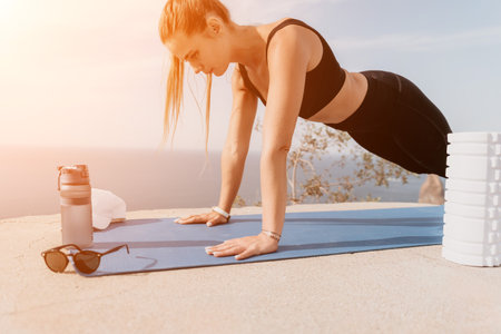 Fitness woman sea. Outdoor workout on yoga mat roller in park near to ocean beach. Female fitness...