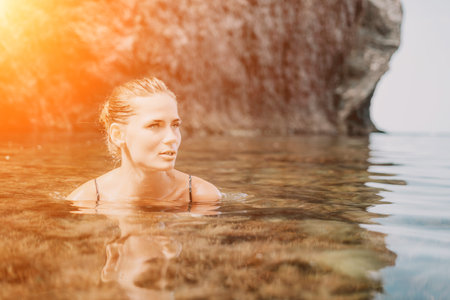 Woman travel sea. Happy tourist enjoy taking picture outdoors for memories. Woman traveler swim in the sea bay with mountains, sharing travel adventure journeyの写真素材