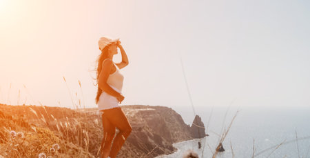 Woman summer travel sea. Happy tourist enjoy taking picture outdoors for memories. Woman traveler posing over sea bay surrounded by volcanic mountains, sharing travel adventure journeyの写真素材