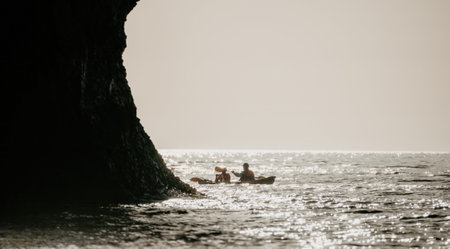 Happy couple kayaks in an inflatable kayak on the sea at sunset. Couple kanoeing in the sea near the...
