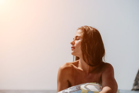 Woman summer sea. Happy woman swimming with inflatable donut on the beach in summer sunny day, surrounded by volcanic mountains. Summer vacation concept.の写真素材
