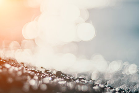 Blurred golden sea at sunset. The sun reflects and sparkles on the waves with bokeh, illuminating the golden sea. Holiday recreation concept. Abstract nautical summer ocean sunset nature background.の写真素材