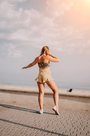 Woman summer dance. Silhouette of a happy woman who dances, spins and raises her hands to the sky. A...