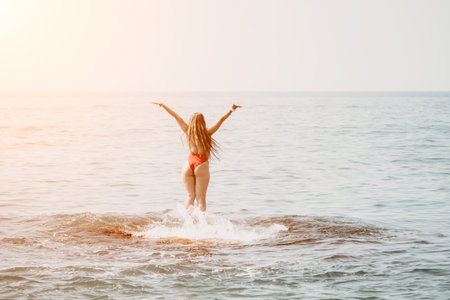 Woman sea yoga. Happy woman meditating in yoga pose on the beach, ocean and rock mountains. Motivation and inspirational fit and exercising. Healthy lifestyle outdoors in nature, fitness concept.の写真素材
