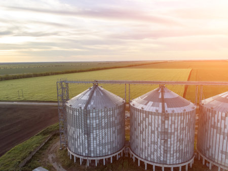 Modern metal silos on agro-processing and manufacturing plant. Aerial view of Granary elevator...