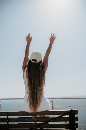 Woman summer travel sea. Happy tourist enjoy taking picture outdoors for memories. Woman traveler posing over sea bay surrounded by volcanic mountains, sharing travel adventure journeyの写真素材