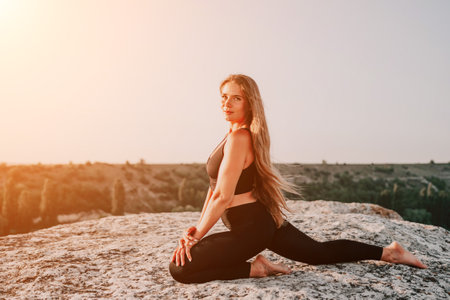 Fitness woman. Happy middle-aged fitness woman doing stretching and pilates on a rock near forest at sunset. Female fitness yoga routine. Healthy lifestyle with focus on well-being and relaxation.の写真素材