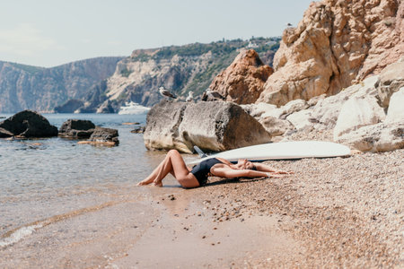Woman summer travel sea. Happy tourist enjoy taking picture outdoors for memories. Woman traveler posing on the beach at sea surrounded by volcanic mountains, sharing travel adventure journeyの写真素材