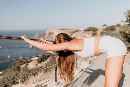 Fitness woman sea. Outdoor workout in park over beach. Female fitness pilates yoga routine concept. Healthy lifestyle. Happy fit woman exercising with rubber band in park.の写真素材
