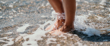 A woman walks along the beach, legs close-up. Barefoot woman staの写真素材