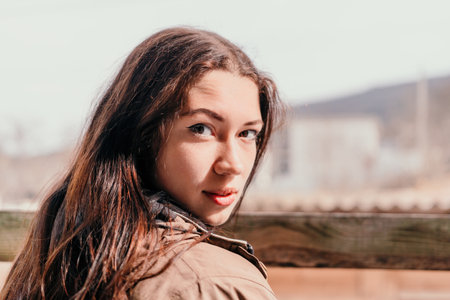 Happy young smiling woman with freckles outdoors portrait. Soft sunny colors. Outdoor close-up...