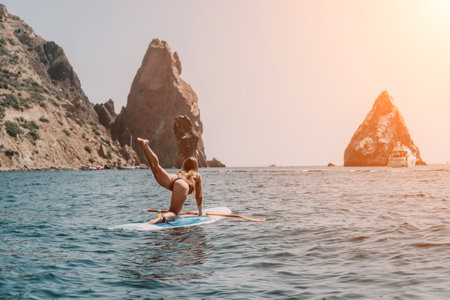 Woman sea sup. Close up portrait of happy young caucasian woman with long hair looking at camera and smiling. Cute woman portrait in bikini posing on sup board in the seaの写真素材