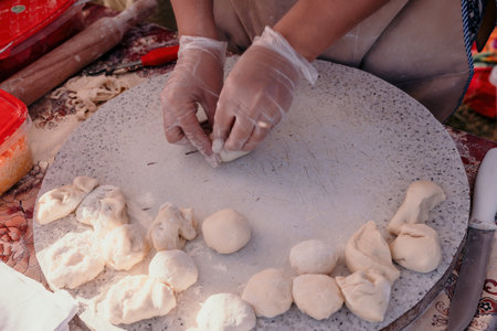 womans hands making qutab or chebureki with a rolling pin and minced meat onion in dough for culinary concepts related to Azerbaijani, Tatar and Greek cuisine, as well as empanadas in Latin America.の写真素材