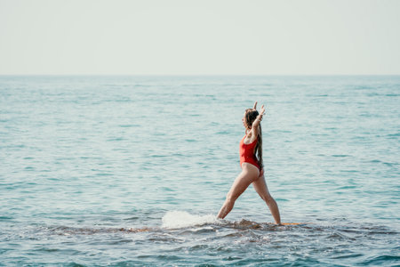 Woman sea yoga. Back view of free calm happy satisfied woman with long hair standing on top rock...