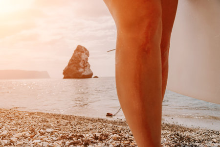 Woman sea sup. Close up portrait of happy young caucasian woman with long hair looking at camera and smiling. Cute woman portrait in bikini posing on sup board in the seaの写真素材