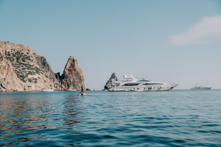 Woman sea sup. Close up portrait of happy young caucasian woman with long hair looking at camera and smiling. Cute woman portrait in bikini posing on sup board in the seaの写真素材