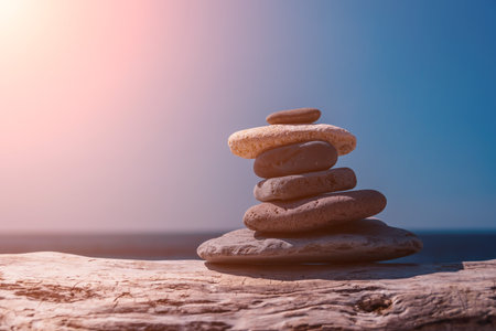 Pyramid stones on the seashore on a sunny day on the blue sea background. Happy holidays. Pebble beach, calm sea, travel destination. Concept of happy vacation on the sea, meditation, spa, calmness.の写真素材