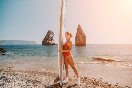 Woman sea sup. Close up portrait of happy young caucasian woman with blond hair looking at camera and smiling. Cute woman portrait in red bikini posing on sup board in the seaの写真素材