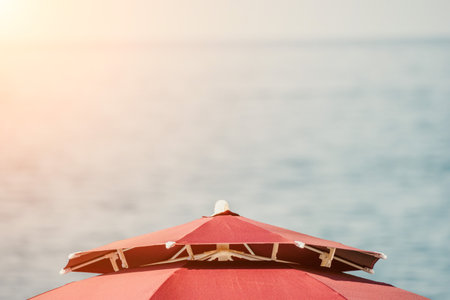 Red Beach Umbrella on the Background of the Blue Sea Ocean. Beach Landscape. Summer travel and holidays concept.の写真素材