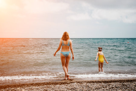 Happy loving family mother and daughter having fun together on the beach. Mum playing with her kid in holiday vacation next to the ocean - Family lifestyle and love conceptの写真素材