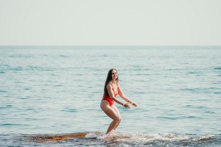 Woman sea yoga. Back view of free calm happy satisfied woman with long hair standing on top rock with yoga position against of sky by the sea. Healthy lifestyle outdoors in nature, fitness conceptの写真素材